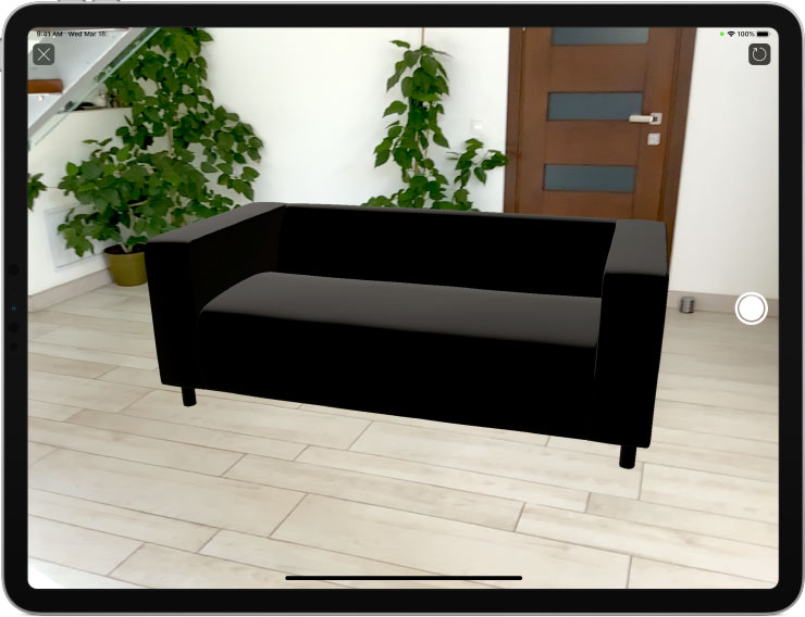 An IKEA sofa 3D object viewed in AR in Live Home 3D on an iPad
