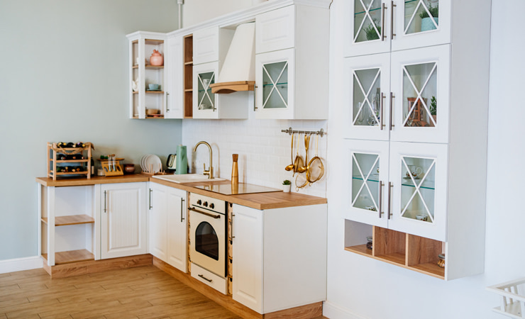 A small white kitchen with glass-paneled cabinetry.