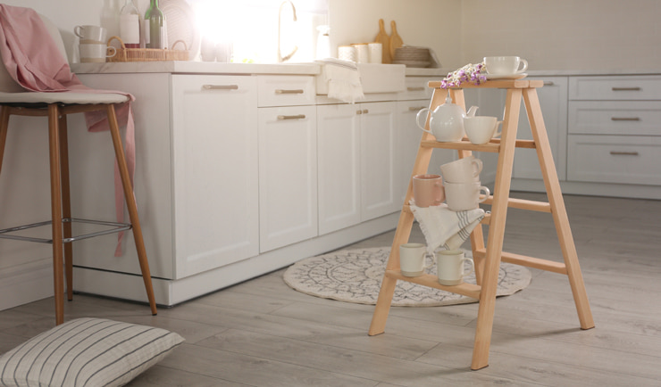 A small white kitchen with a ladder as an element of decor.