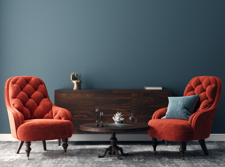 Elegant dark interior with bright red armchairs.
