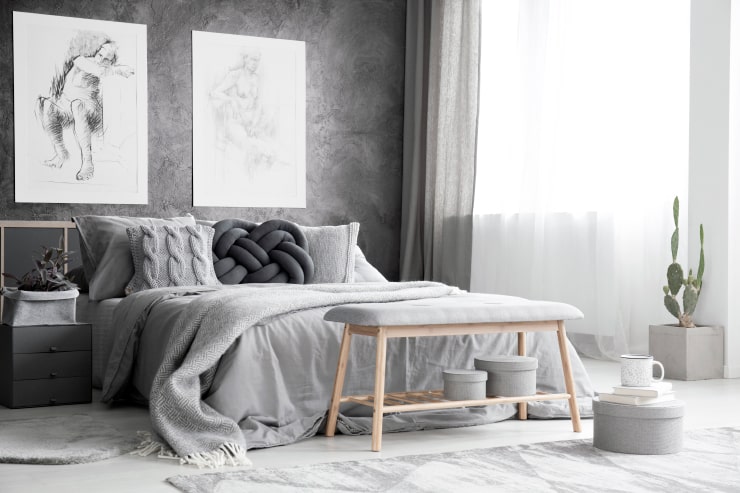A bedroom in gray tones with a textured wall
