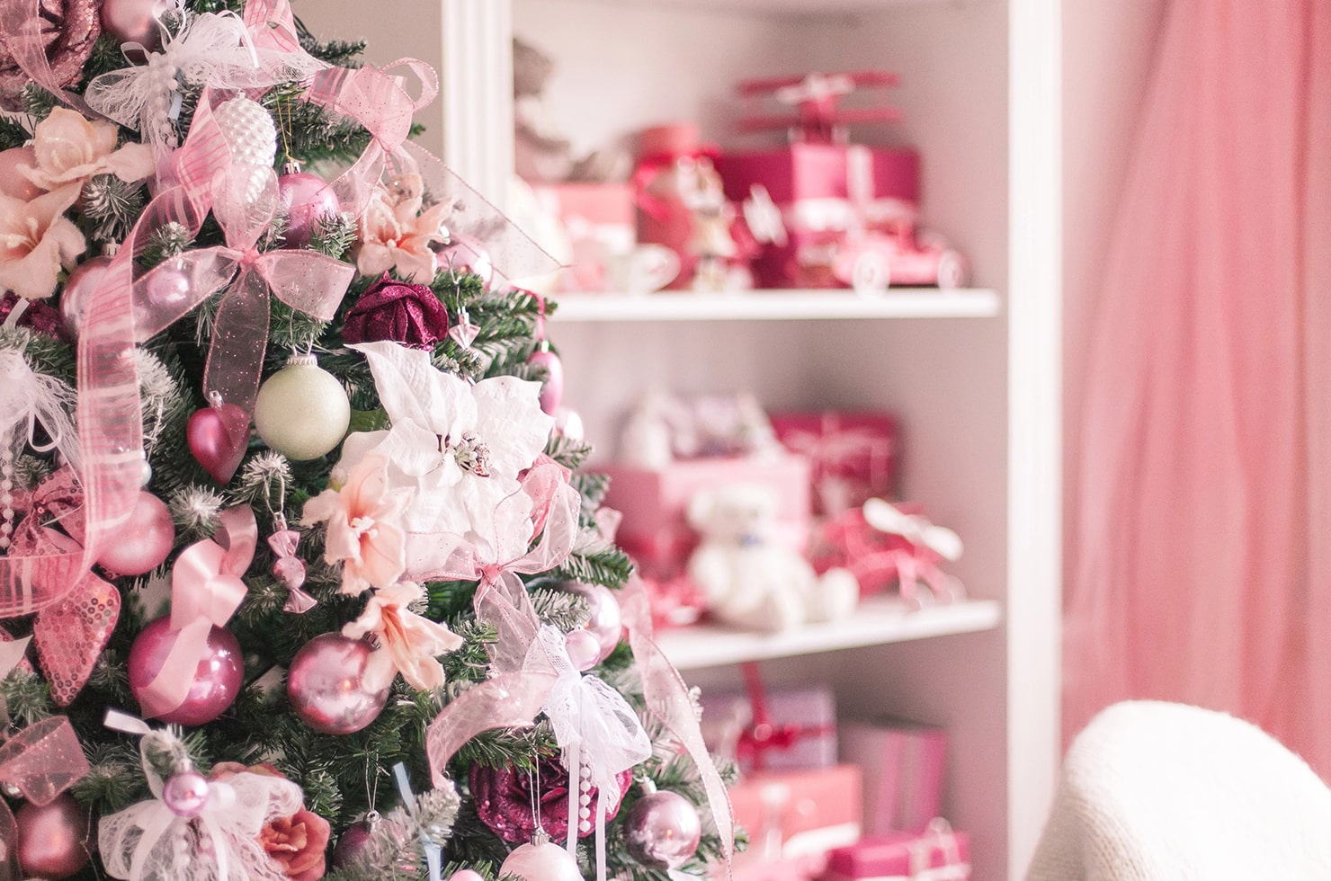 A room decorated for a Barbie-themed Christmas, with pink bows and baubles adorning the Christmas tree.