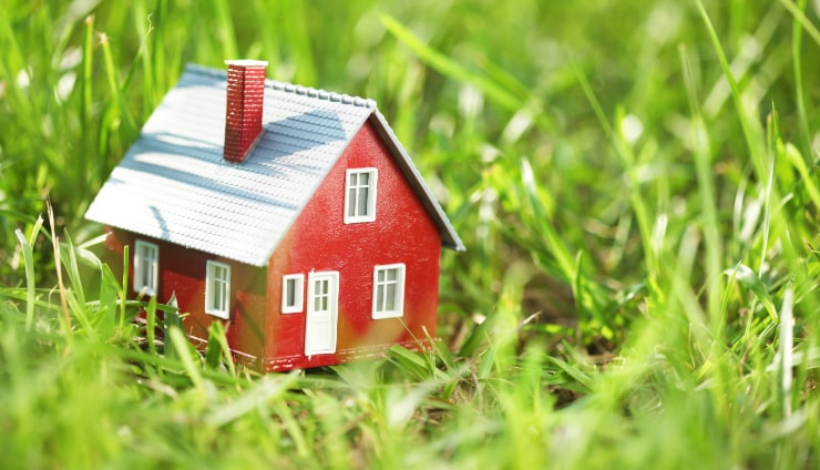 A tiny red house on grass