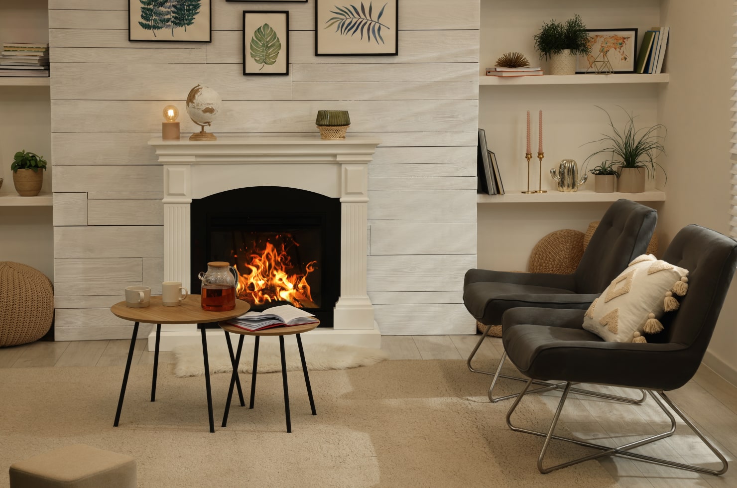Cozy living room with two gray armchairs and a fireplace.