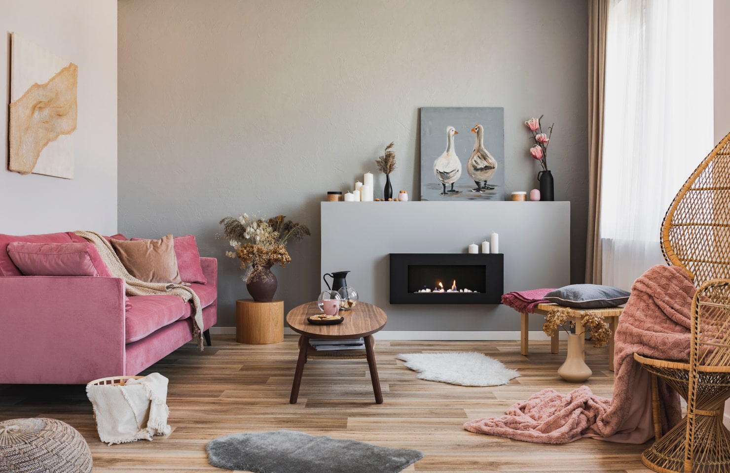 Contemporary living room with a pink sofa, wooden furniture and electric fireplace.
