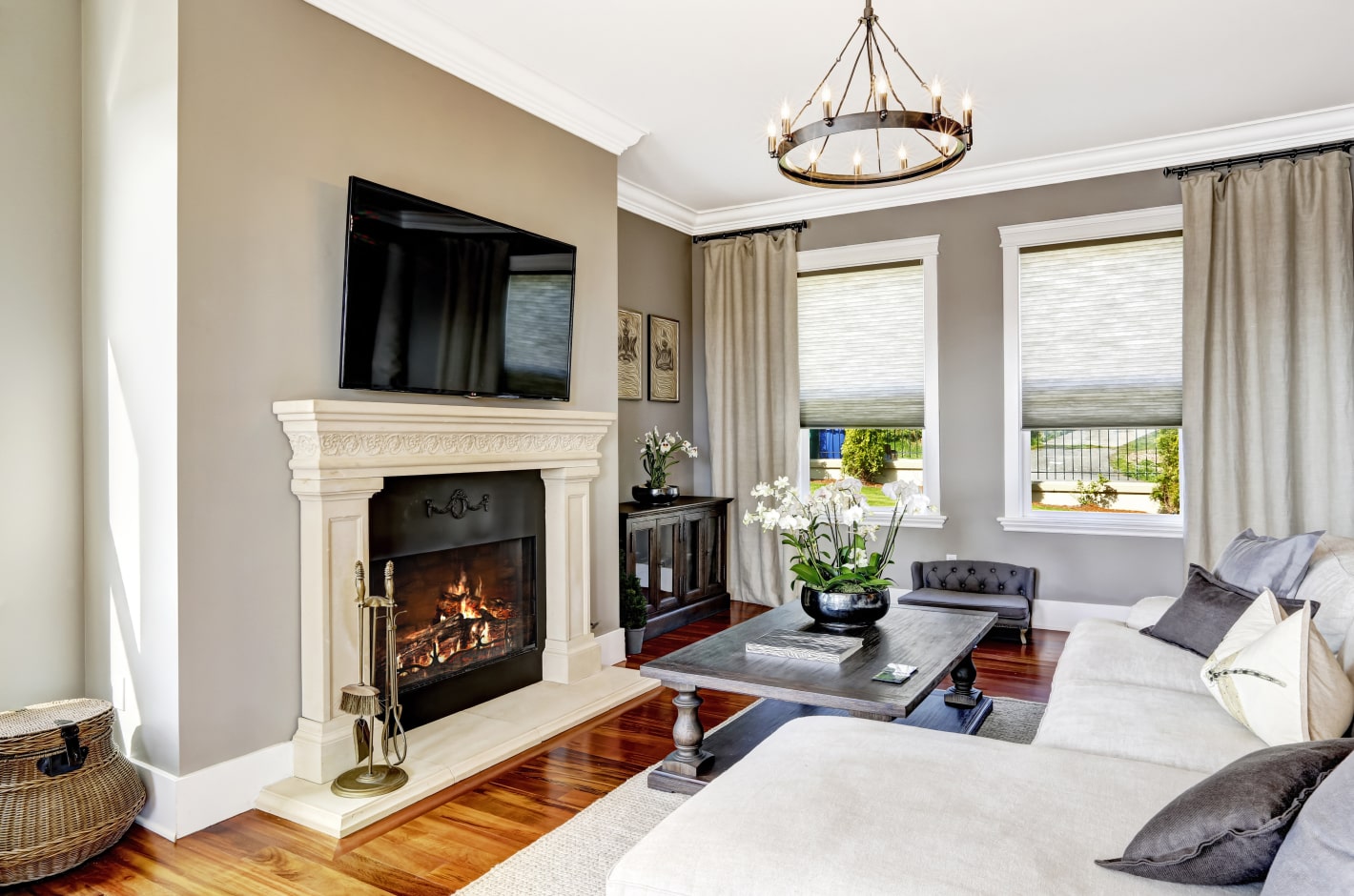Luxurious living room with a big sofa, chandelier and a fireplace.