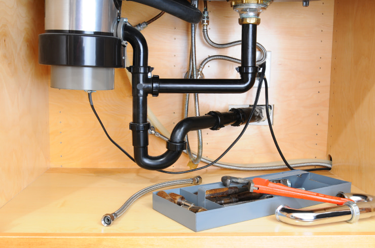 Pipes under a kitchen sink.