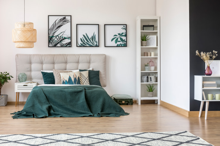 Bedroom in natural tones with a group of pictures hanging on the wall.