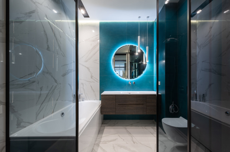 Contemporary bathroom with neon lights installed behind a mirror.