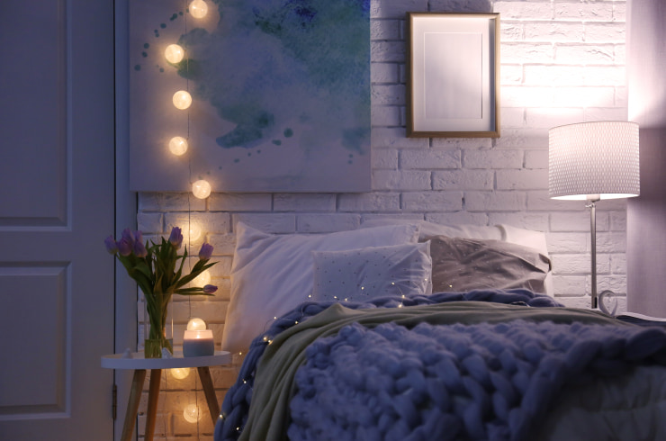 Cozy bed with a very peri purple throw blanket.