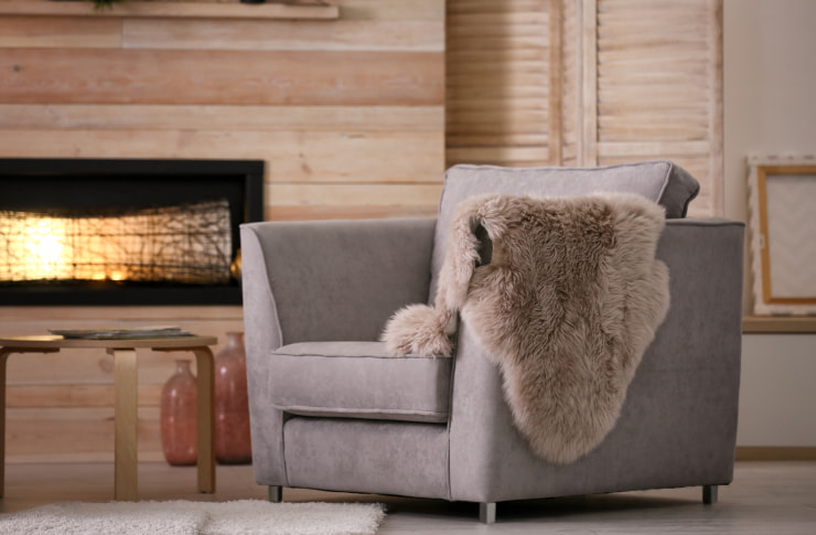 Gray armchair with a sheepskin throw.
