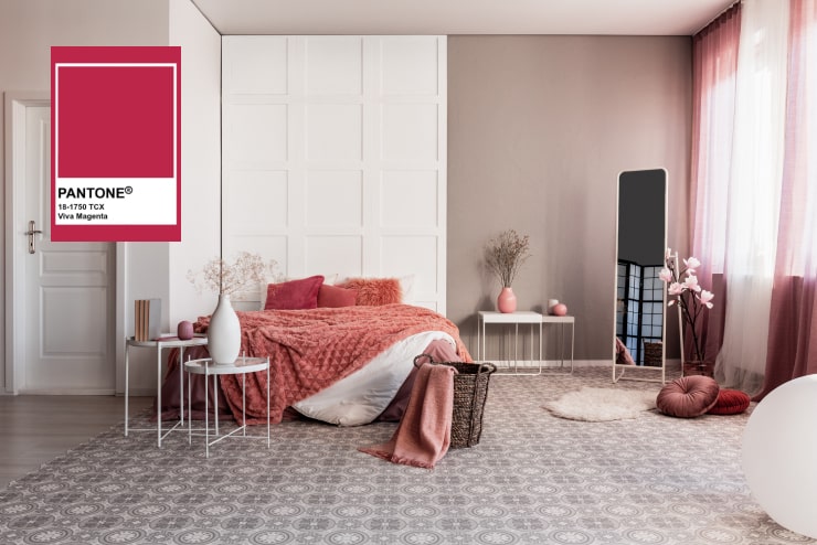 Cozy bed with viva magenta throw pillows.
