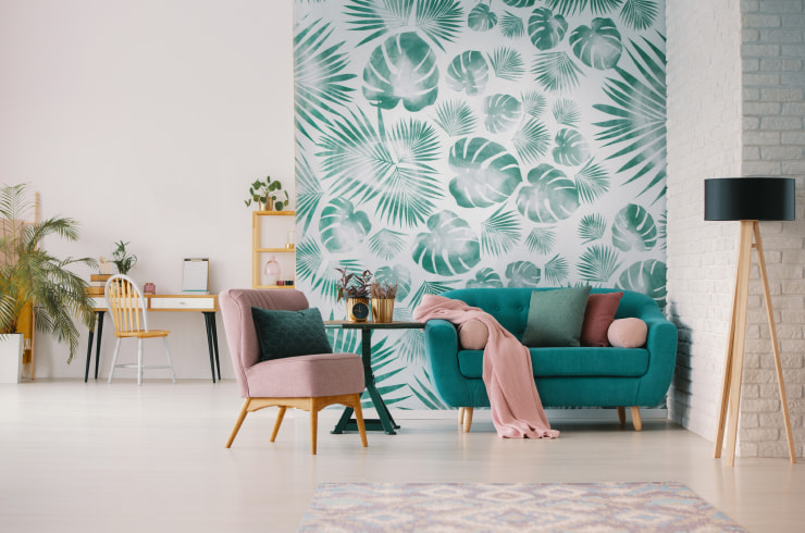 Vivid studio apartment design with a leaf wallpaper used to accent the wall.