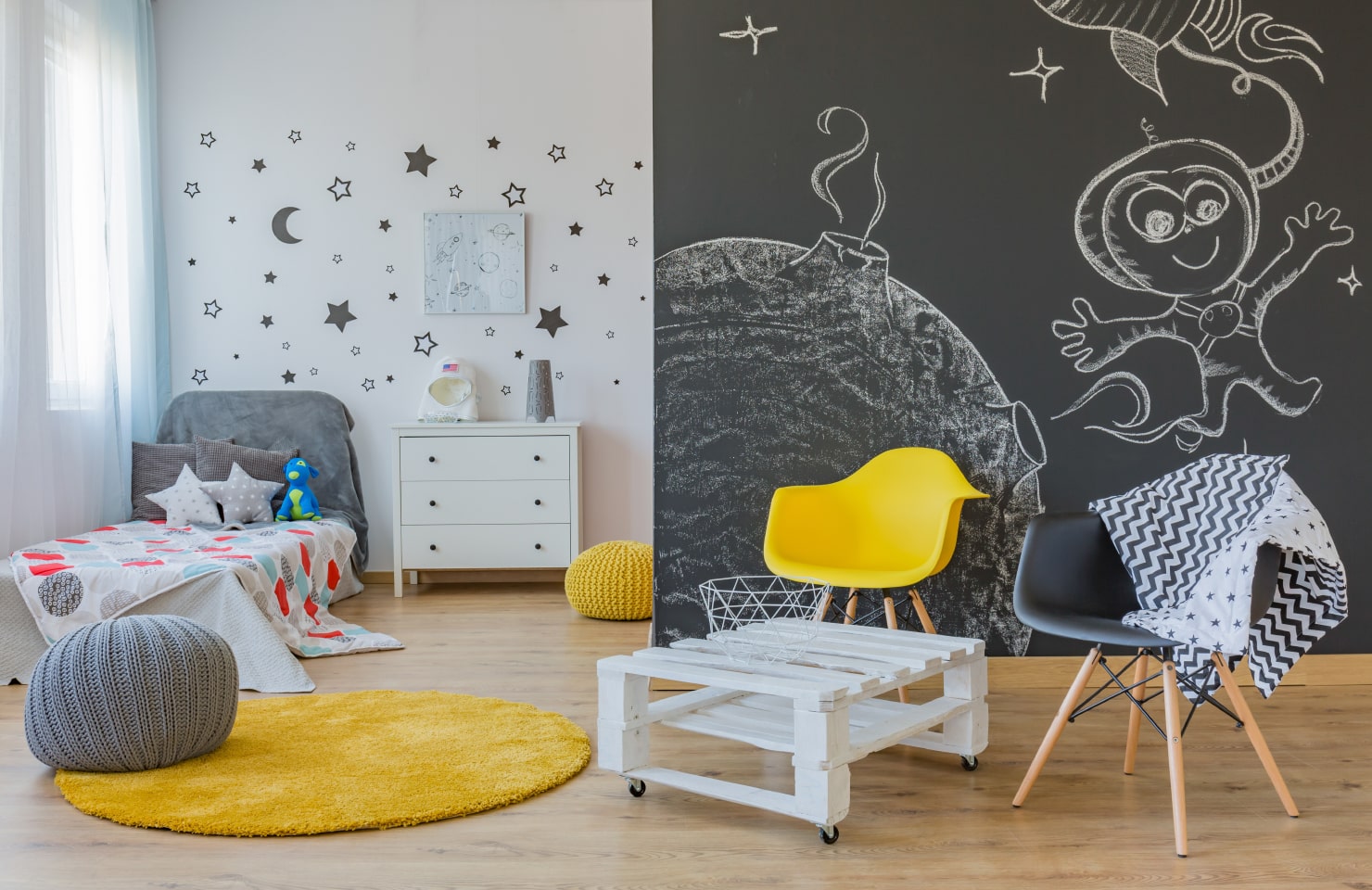 Kid’s room with a space-themed mural and furniture.