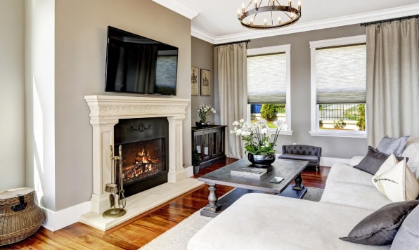 Luxurious living room with a big sofa, chandelier and a fireplace.