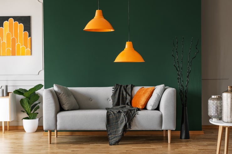 An interior design with bright orange lamps, pillow and painting
