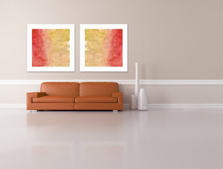 A minimalist living room with a sofa, vases, and paintings