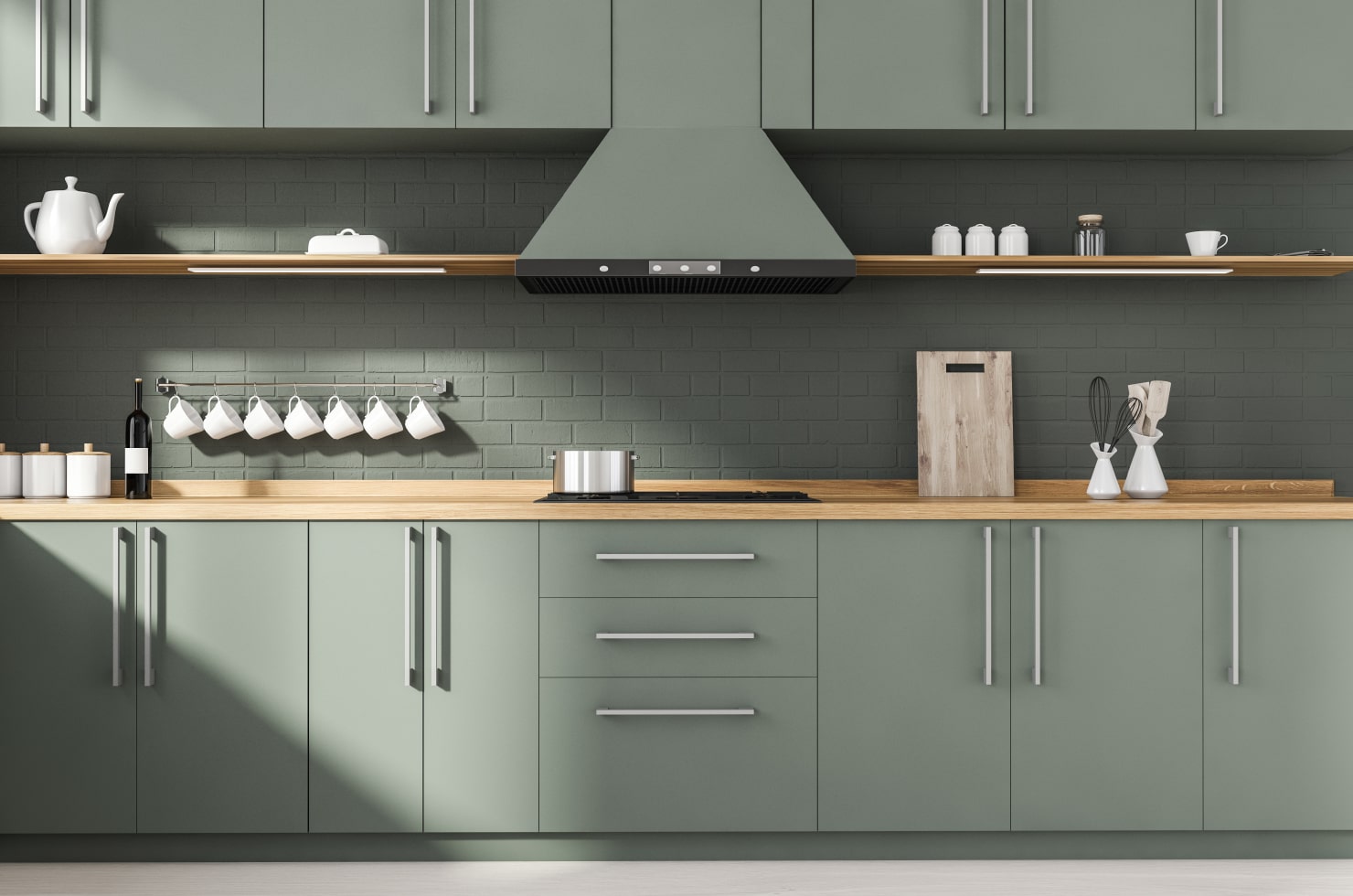 Sage green kitchen with painted brick walls and stylish white jars and other accessories.