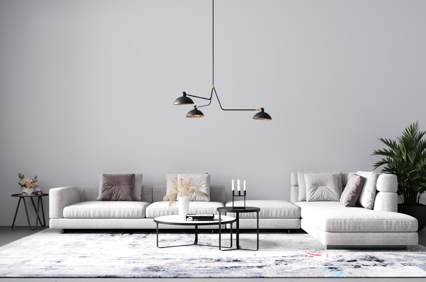 Spacious living room in gray and white tones with a large sofa and a coffee table consisting of two round tables of different heights.