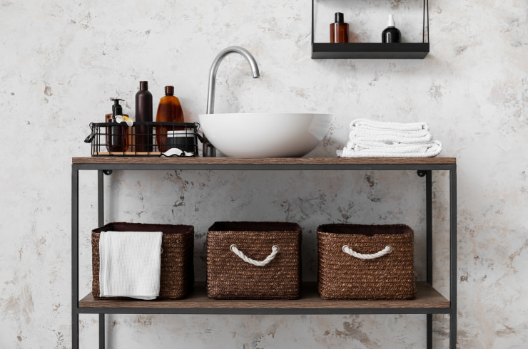 Organizers for bathroom accessories standing near and under the sink.