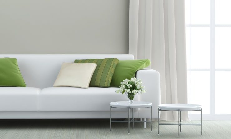 A white sofa with flowers and a window