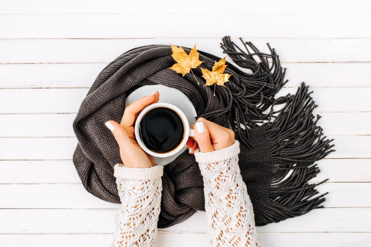 A woman holding a cup of coffee in her hands