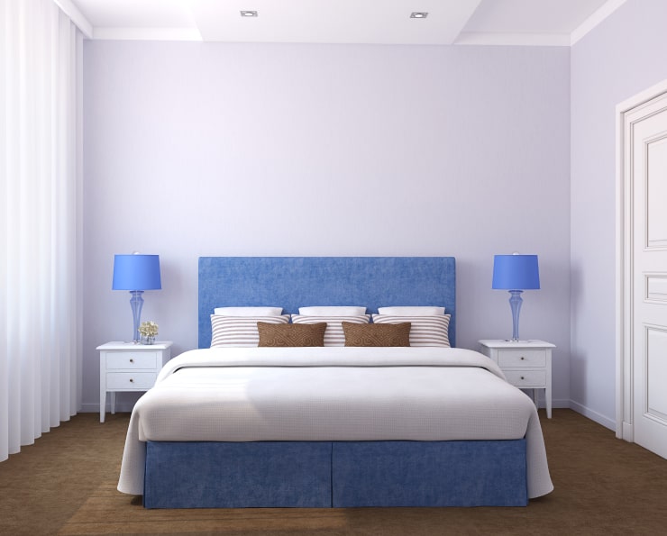 A small white bedroom with blue accents.