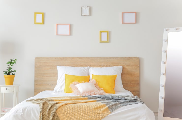 A white bedroom with bright orange accents.